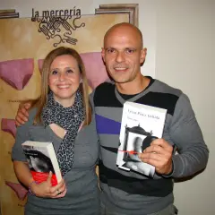 Pareja sonriente posa con dos libros de César Pérez Gellida: "Memento mori" y "Dies irae".