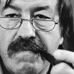 Primer plano de un hombre con gafas y bigote tupido, sosteniendo un bolígrafo. Podría ser uno de los escritores alemanes actuales.