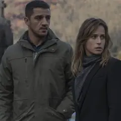 Un hombre y una mujer en un cementerio, con aspecto preocupado. Podría ser una escena del resumen de "Ofrenda a la tormenta".