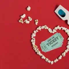 Palomitas forman un corazón con entradas de cine y gafas 3D. ¡La cita perfecta para una romcom!