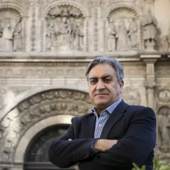 Un hombre con traje posa frente a un edificio histórico, evocando la tradición de los escritores aragoneses actuales.