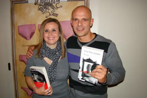 Pareja sonriente posa con dos libros de César Pérez Gellida: "Memento mori" y "Dies irae".
