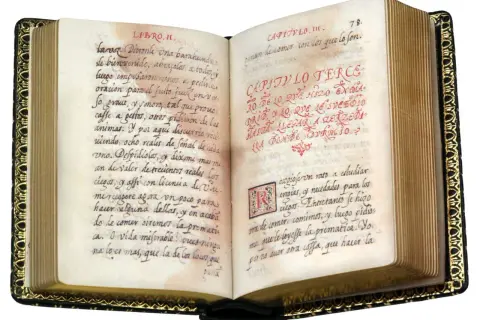Libro antiguo abierto con escritura a mano en español. Se lee "historia de la vida del buscon" en el texto.