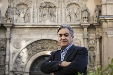 Un hombre con traje posa frente a un edificio histórico, evocando la tradición de los escritores aragoneses actuales.