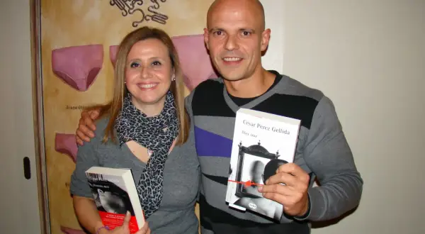 Pareja sonriente posa con dos libros de César Pérez Gellida: "Memento mori" y "Dies irae".