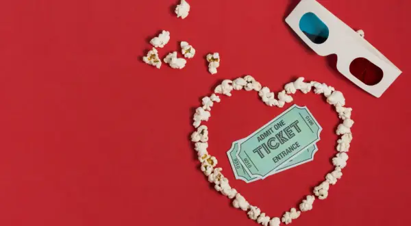 Palomitas forman un corazón con entradas de cine y gafas 3D. ¡La cita perfecta para una romcom!