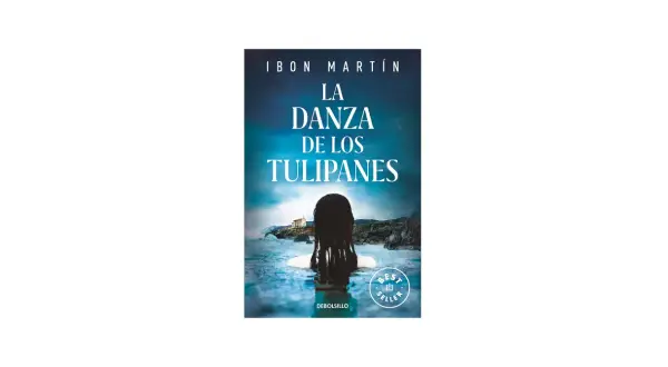 La sinopsis de "La danza de los tulipanes" se revela en esta portada: una mujer emerge del agua, mirando hacia una casa en la costa.