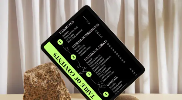 Una tablet muestra un índice de contenidos con un estilo "dark academia", rodeada de rocas y cortinas.