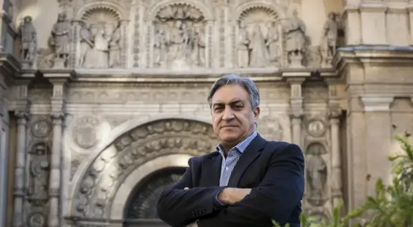 Un hombre con traje posa frente a un edificio histórico, evocando la tradición de los escritores aragoneses actuales.