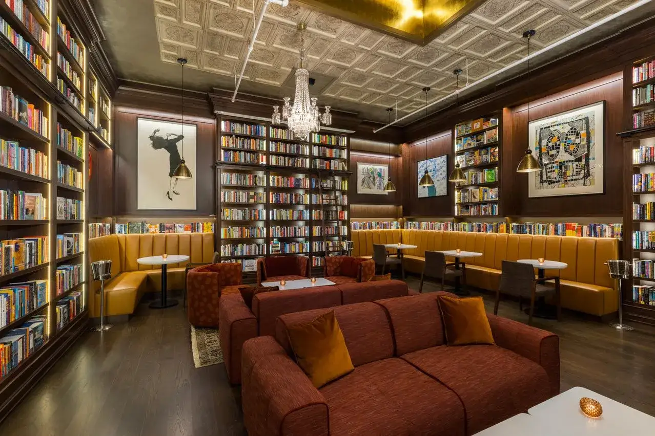 Un espacio acogedor con estanter&iacute;as repletas de libros alegres, sof&aacute;s c&oacute;modos y asientos tipo cabina.