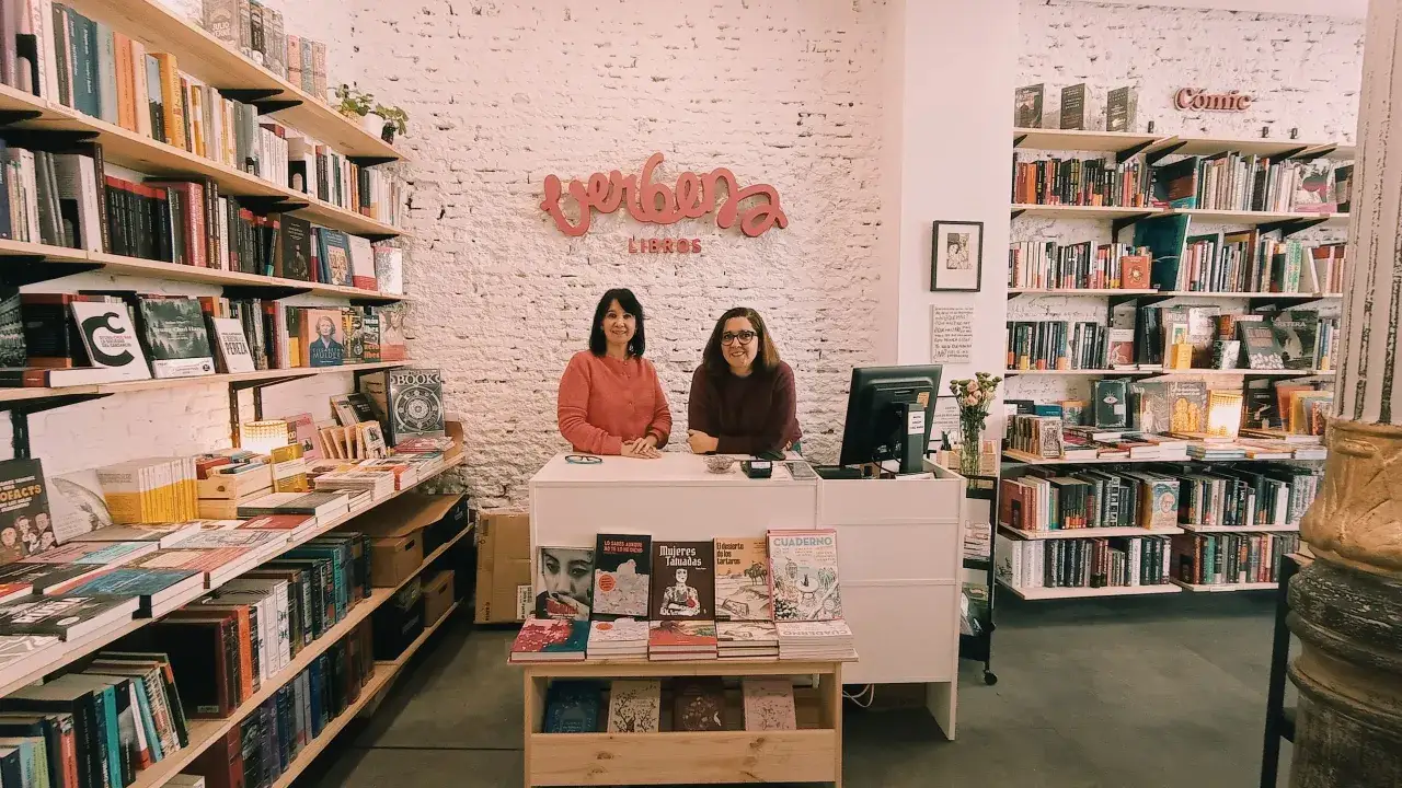Dos mujeres atienden una librería llena de libros, incluyendo algunos de los libros mas buscados.