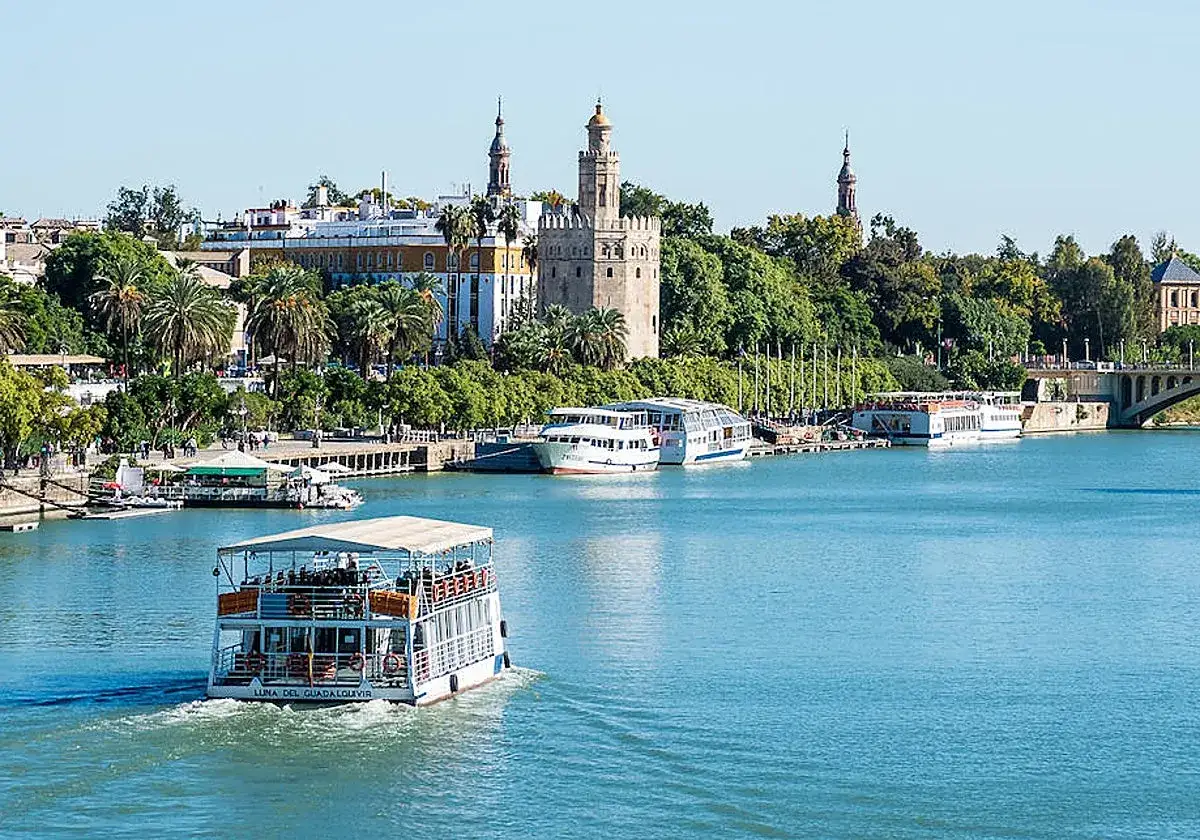 El Guadalquivir, escenario de inspiraci&oacute;n para poetas sevillanos, con la Torre del Oro y barcos tur&iacute;sticos.