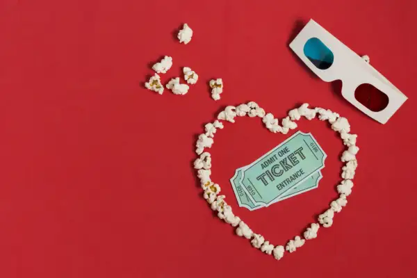 Palomitas forman un corazón con entradas de cine y gafas 3D. ¡La cita perfecta para una romcom!